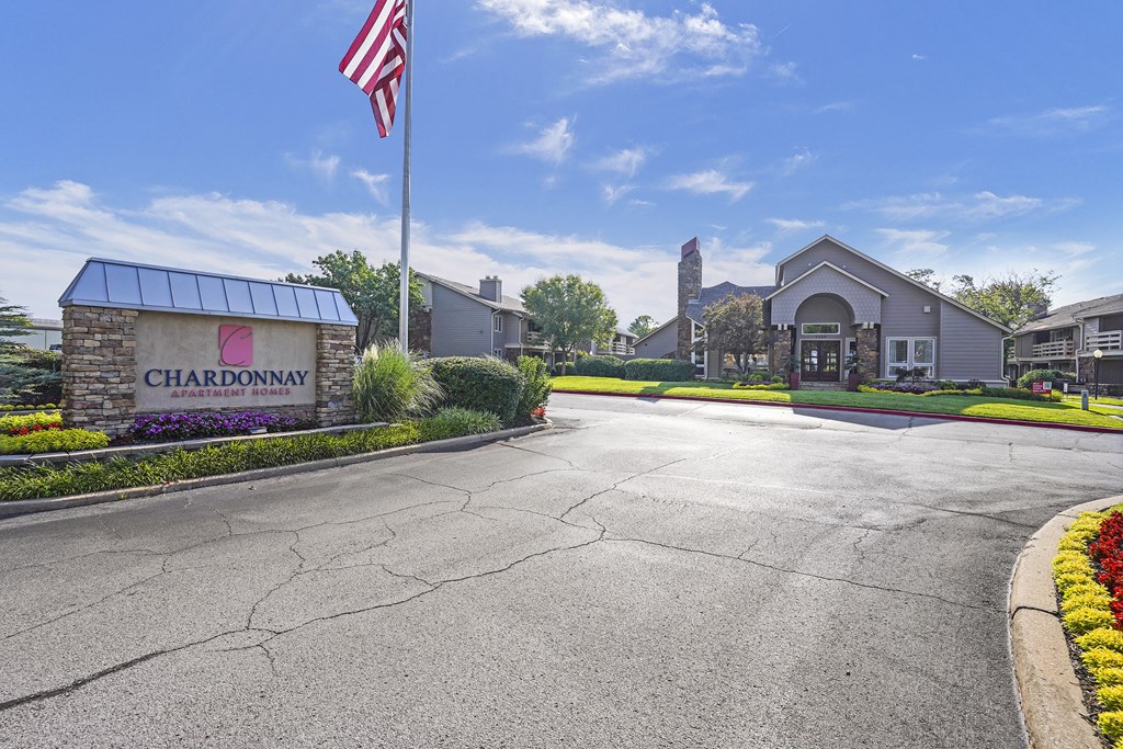 The image shows a Chardonnay sign in front of a building with a flagpole and a clear blue sky.