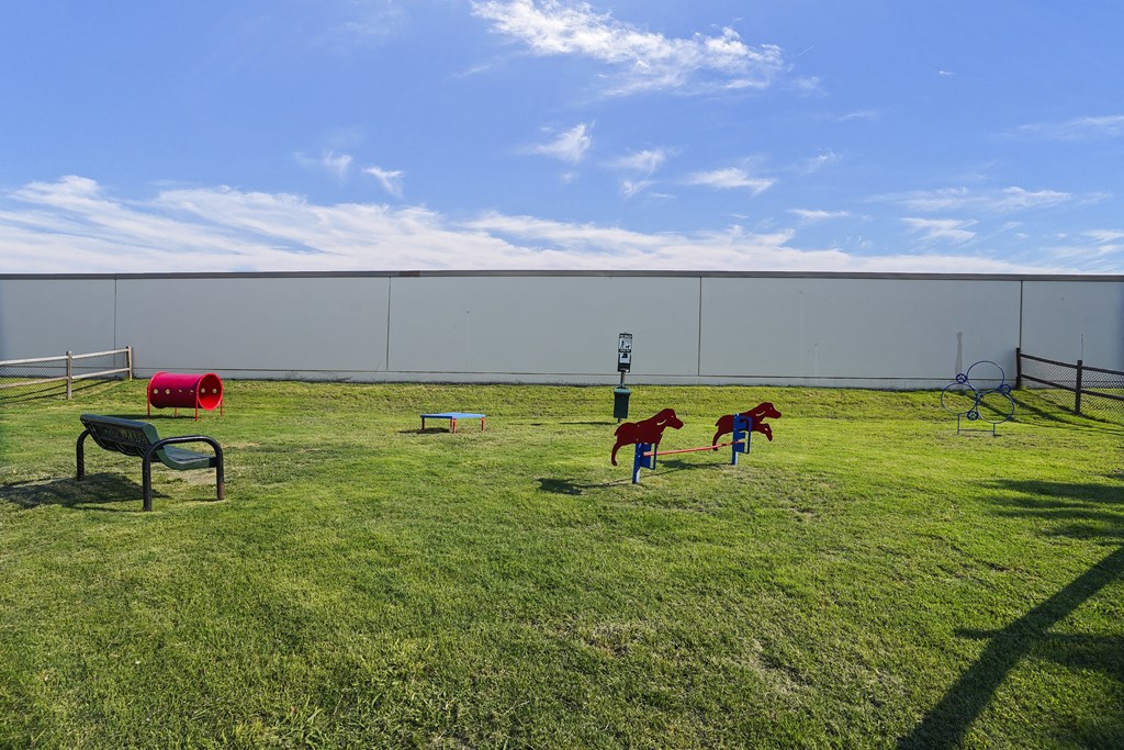 A playground with a red slide and a green bench.