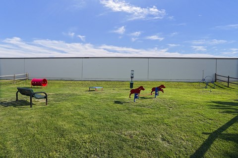 A playground with a red slide and a green bench.