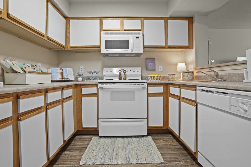 A white oven is in the middle of a kitchen with wooden cabinets.
