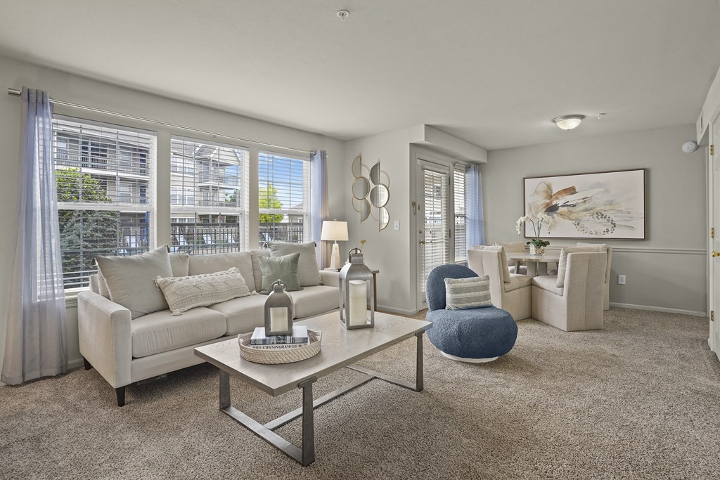 A living room with a white couch, a blue chair, and a coffee table.