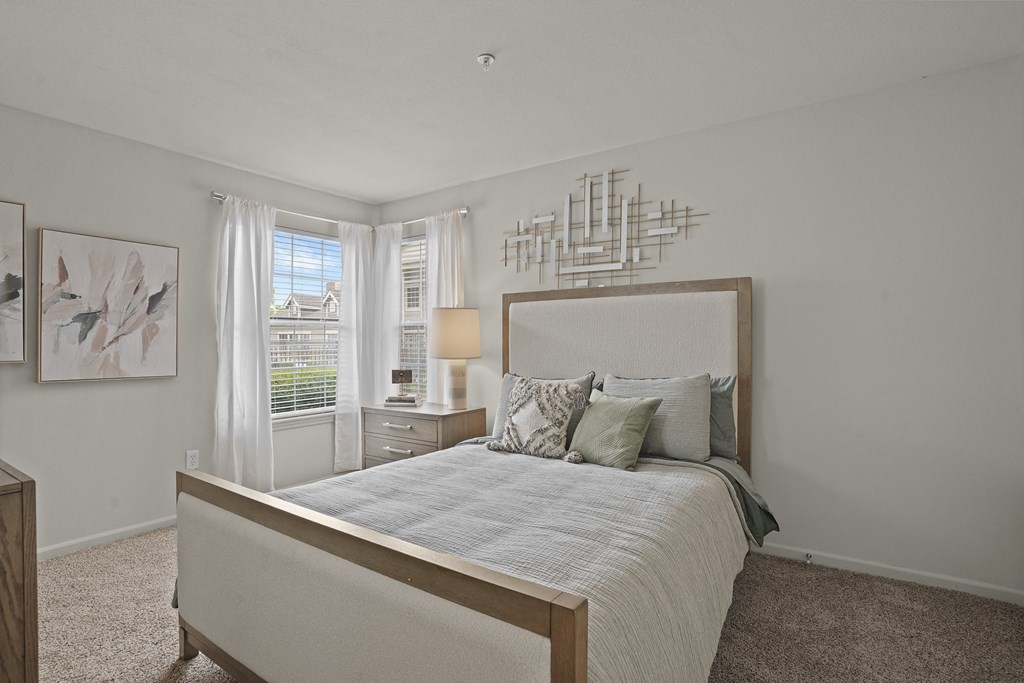 A bedroom with a large bed and a wall art.