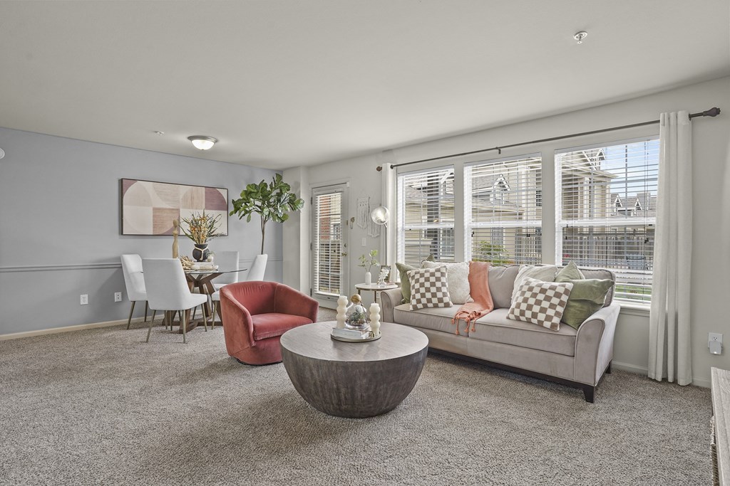 A living room with a grey couch, a red chair, and a coffee table.