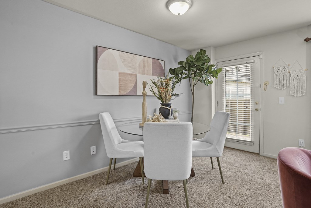 A dining room with a white table and chairs.