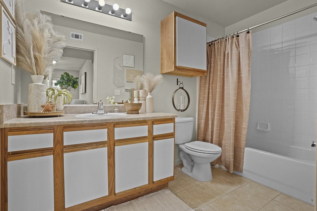 A bathroom with a white toilet and a wooden cabinet.