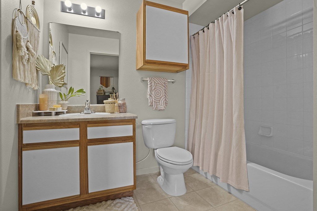 A bathroom with a white toilet and a wooden cabinet.