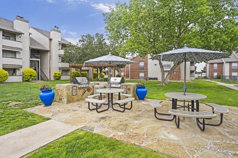 A patio with a table and chairs surrounded by a stone wall.