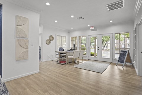 A room with a white wall and a large painting on it.