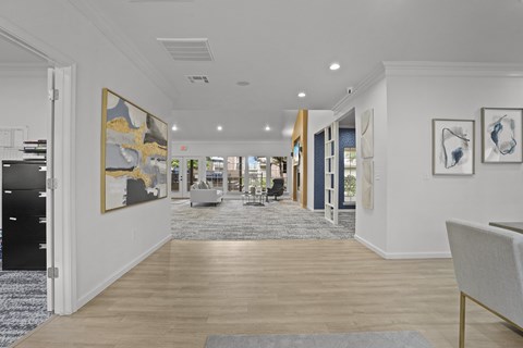A hallway with a rug and a painting on the wall.
