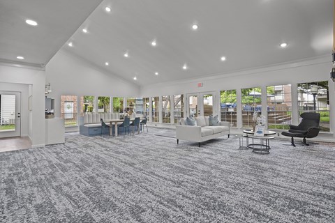 A spacious room with grey carpeting and furniture.