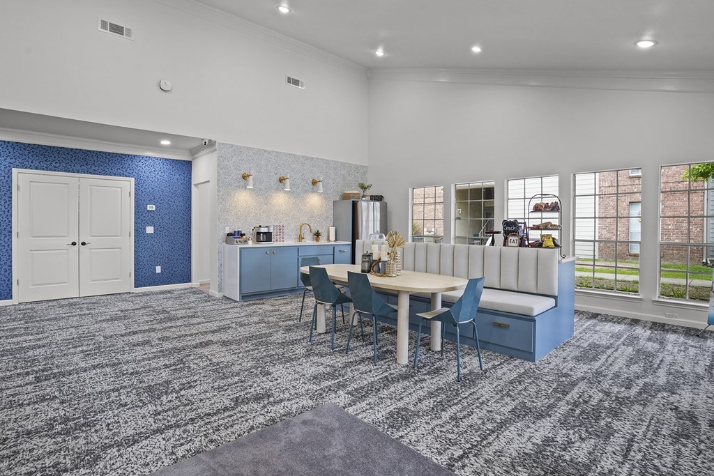 A blue and white kitchen with a dining table and chairs.