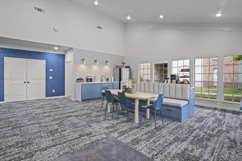 A blue and white kitchen with a dining table and chairs.