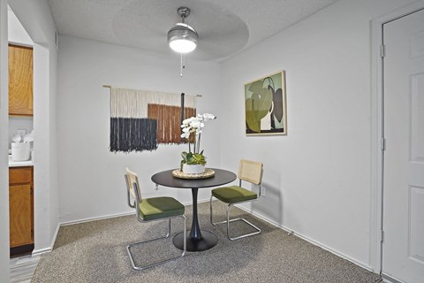 A dining room with a round table and chairs.
