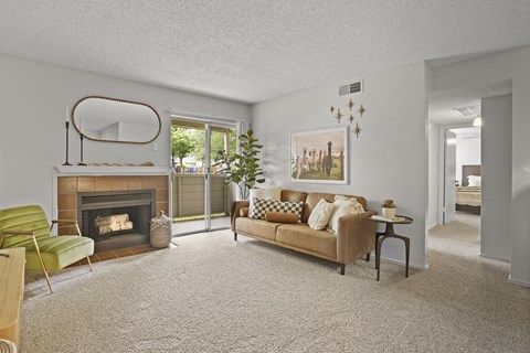 A living room with a fireplace, a couch, and a chair.