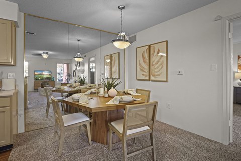 A dining room with a wooden table set for a meal.