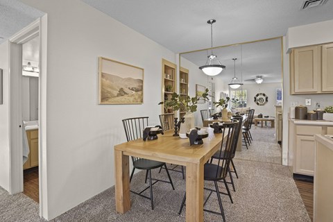 A dining room with a wooden table and chairs.