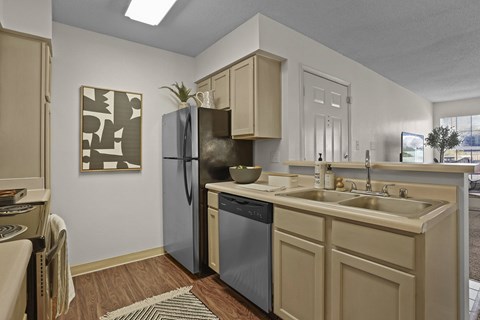 A kitchen with a black fridge and a black dishwasher.
