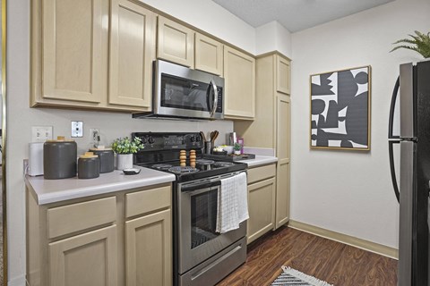 A kitchen with a black stove top oven and a black refrigerator.