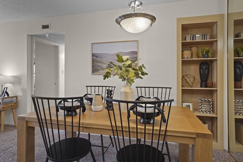 A dining room with a wooden table and chairs.