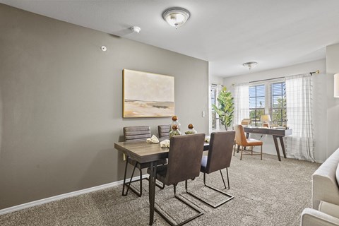A dining room with a table and chairs.