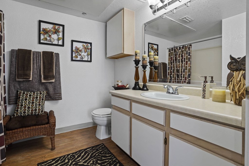 A bathroom with a white sink and a brown chair.