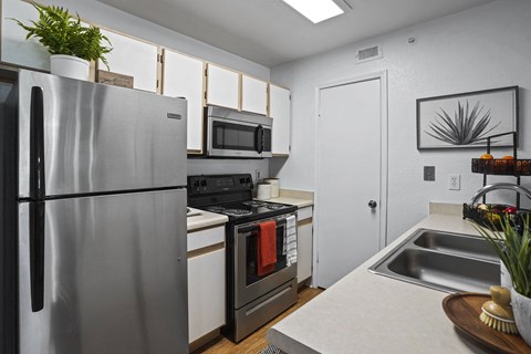 A modern kitchen with stainless steel appliances and a white countertop.