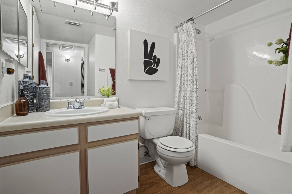 A white bathroom with a toilet, sink, and shower.