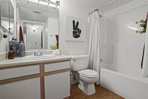 A white bathroom with a toilet, sink, and shower.