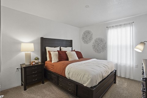 A bedroom with a large bed and two nightstands.