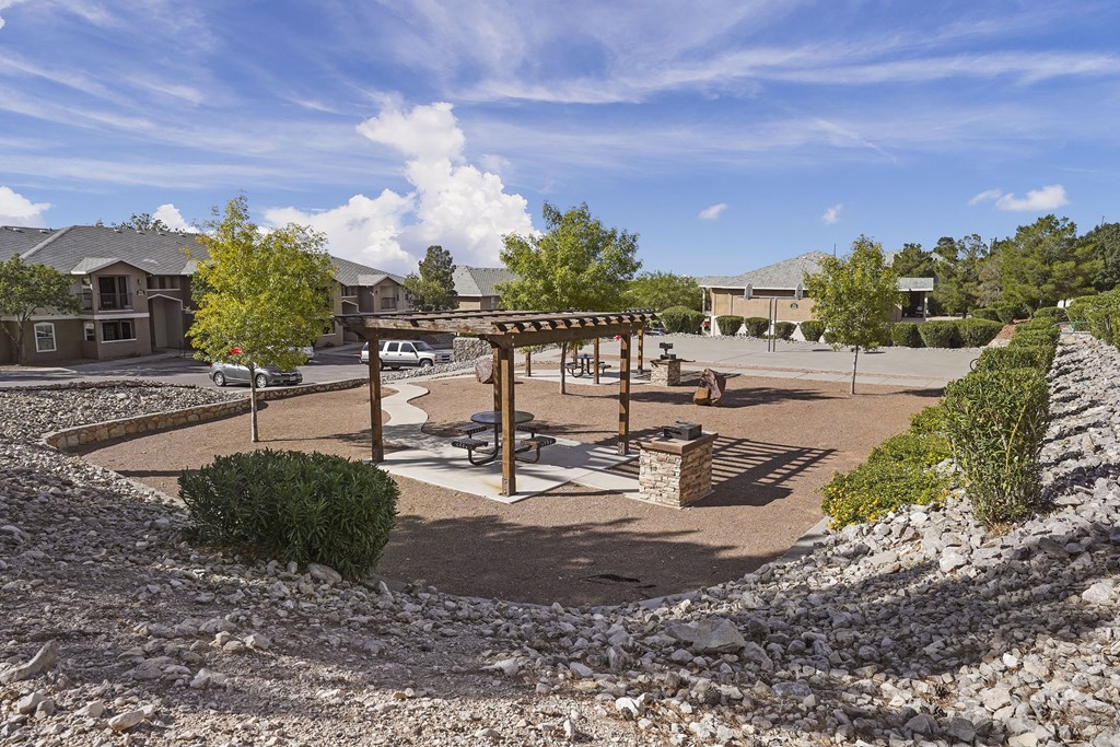 A sunny day at the park with a playground and a picnic table.