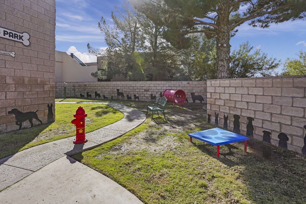 A dog is standing next to a red fire hydrant in a park.