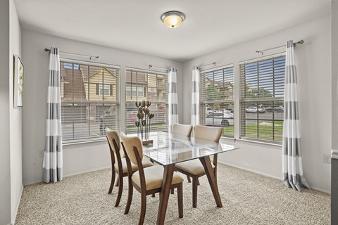 A dining room with a table and chairs.