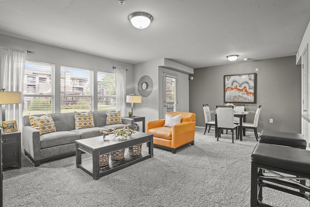 A living room with a grey couch, orange armchair, and a coffee table.