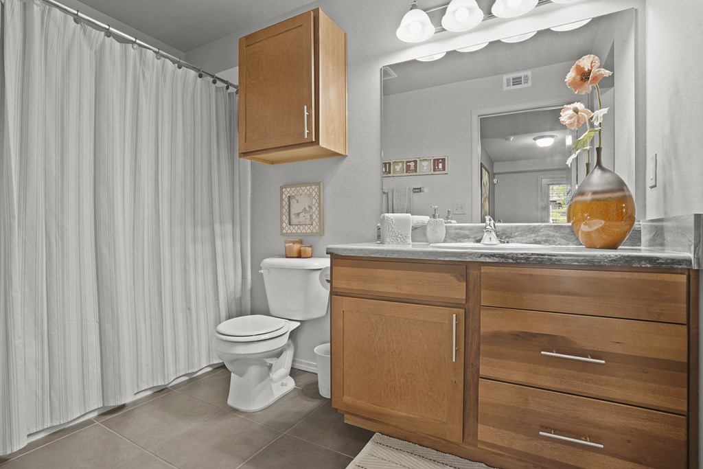 A bathroom with a toilet, sink, and shower curtain.