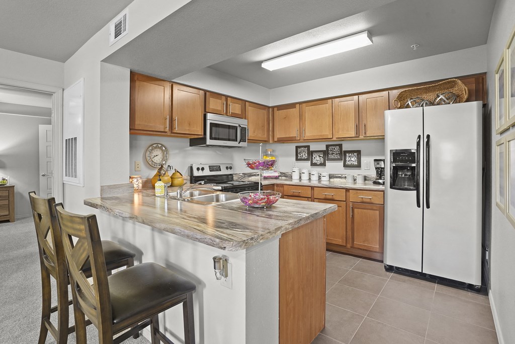 A kitchen with a white refrigerator and wooden cabinets.