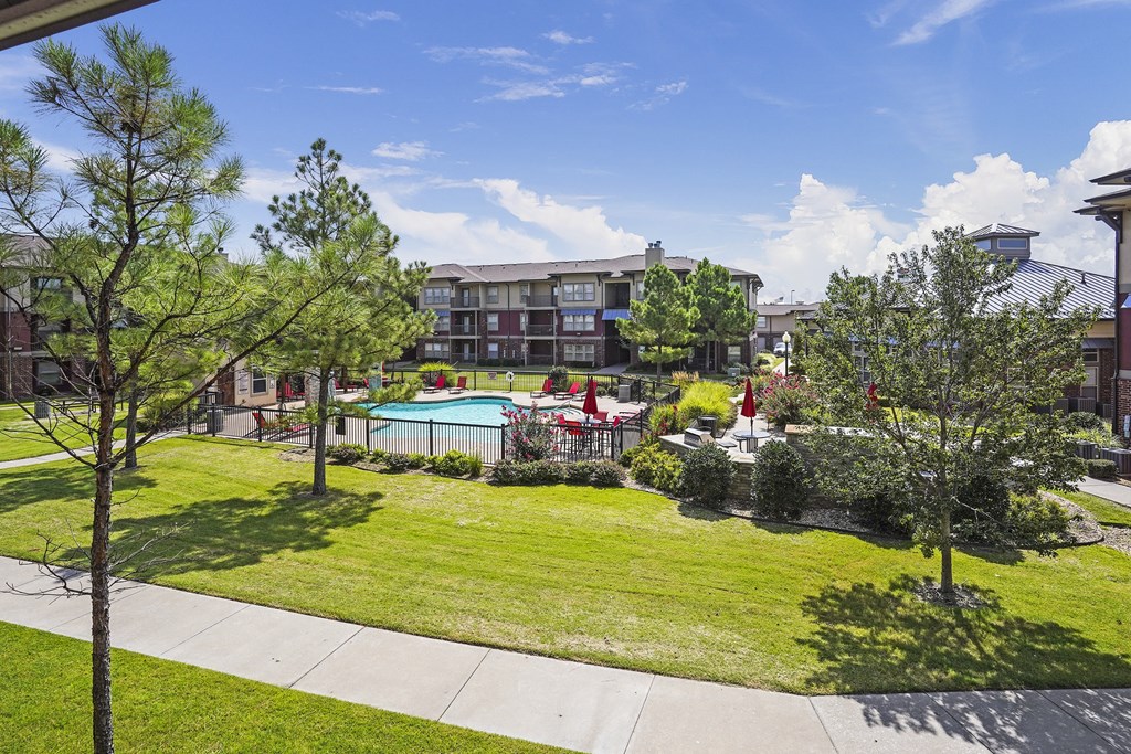 A view of a pool and apartment complex from a balcony.