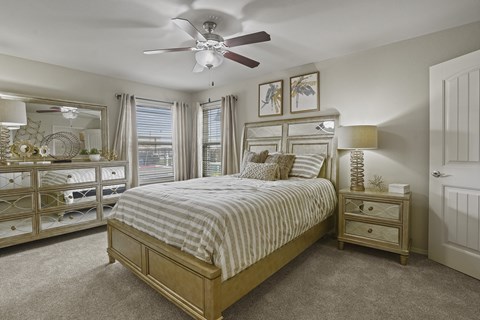 A bedroom with a large bed and a ceiling fan.
