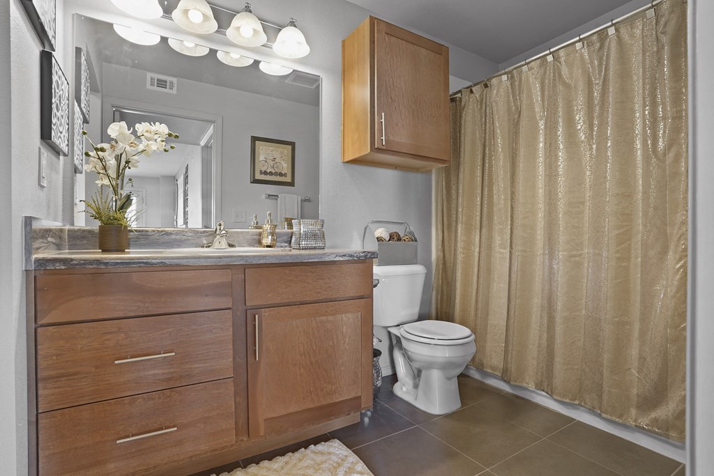 A bathroom with a toilet, sink, and shower curtain.