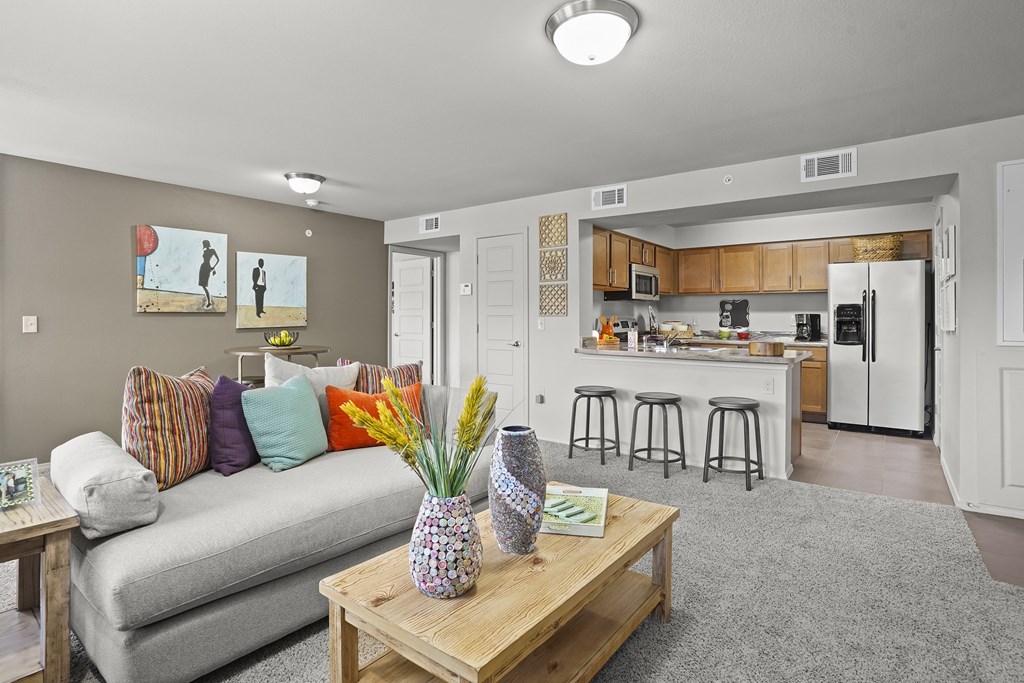 A living room with a grey couch and a wooden coffee table.