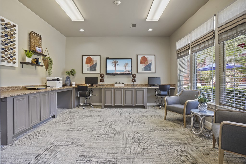 A waiting room with grey chairs and a reception desk.