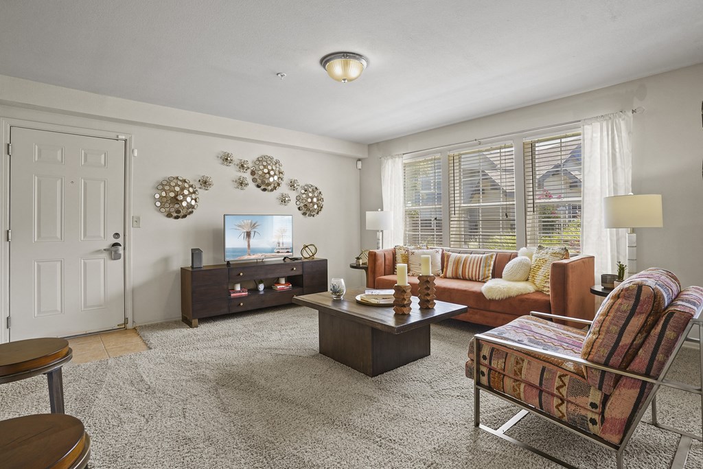 A living room with a couch, chair, and television.