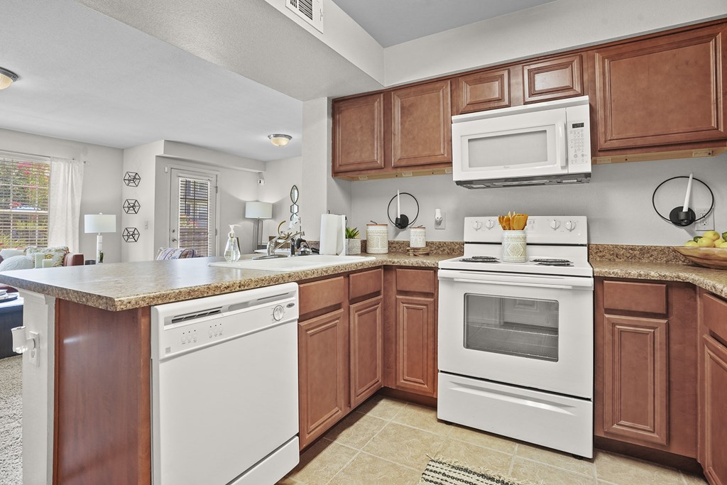 A kitchen with white appliances and brown cabinets.