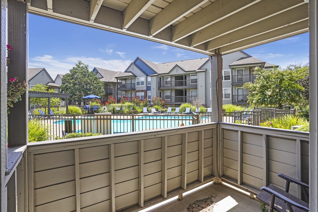 A balcony with a pool and apartment buildings in the background.
