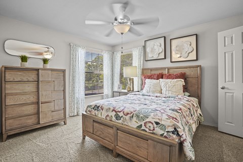 A bedroom with a large bed and a dresser.