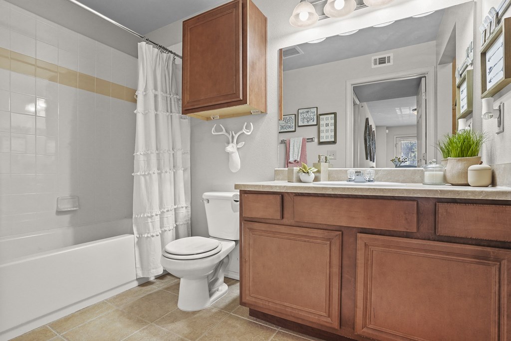 A bathroom with a toilet, a tub, and a mirror.