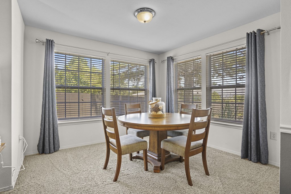A dining room with a round table and chairs.