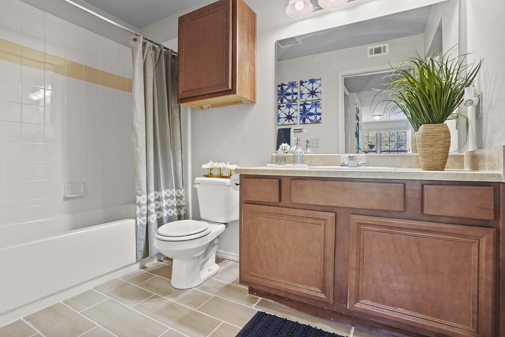 A bathroom with a white toilet and a wooden cabinet.