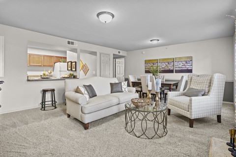 A living room with a white couch, a coffee table, and a painting on the wall.