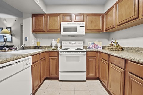 A kitchen with brown cabinets and a white stove top oven.