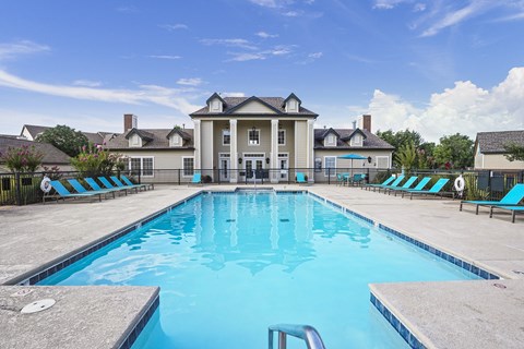 A large swimming pool in front of a house.